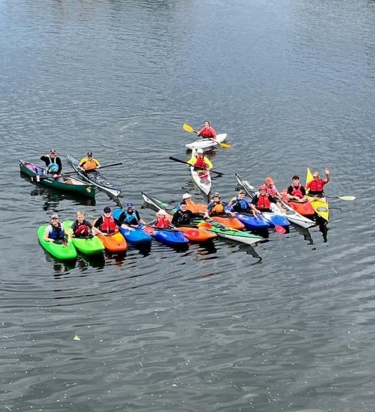 A group of people in kayaks on a lake